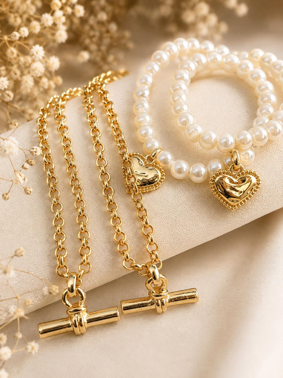 pulseira com pérolas e coração com corrente em T dourada.